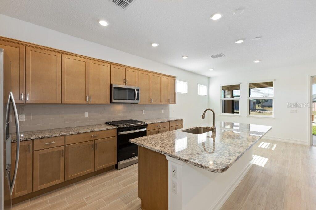 3320 Northwest 52nd Avenue Road Ocala, FL 34482 - Photo 3 of 25 a kitchen with stainless steel appliances granite countertop a sink stove and cabinets