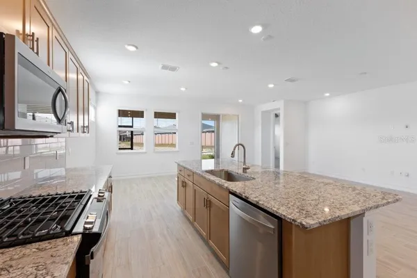 a kitchen with stainless steel appliances granite countertop a sink stove and cabinets