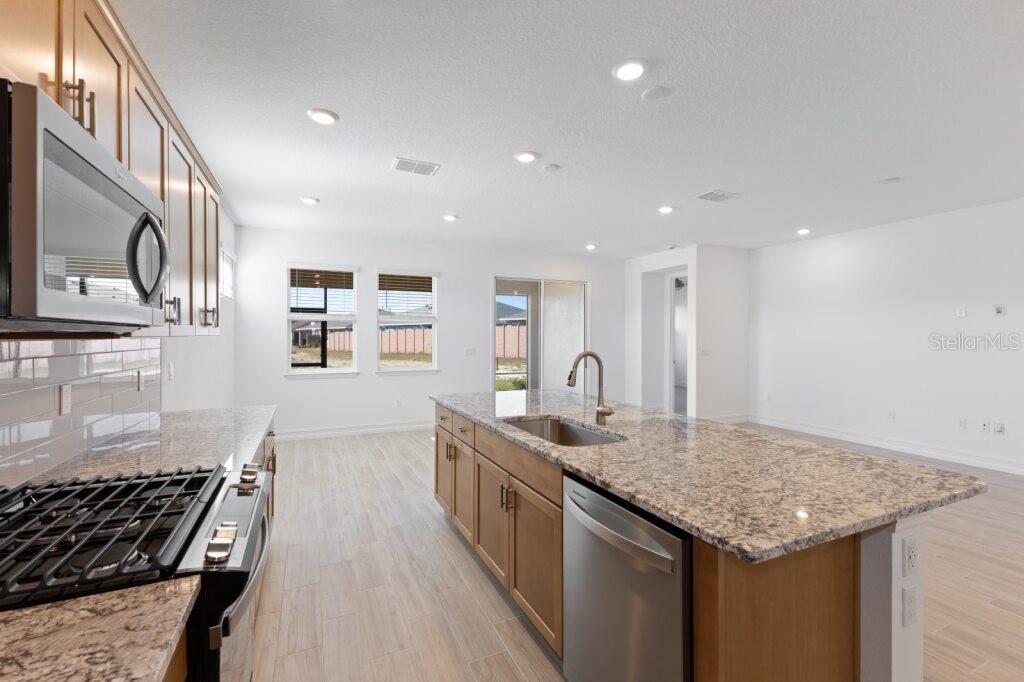 3320 Northwest 52nd Avenue Road Ocala, FL 34482 - Photo 4 of 25 a kitchen with stainless steel appliances granite countertop a sink stove and cabinets