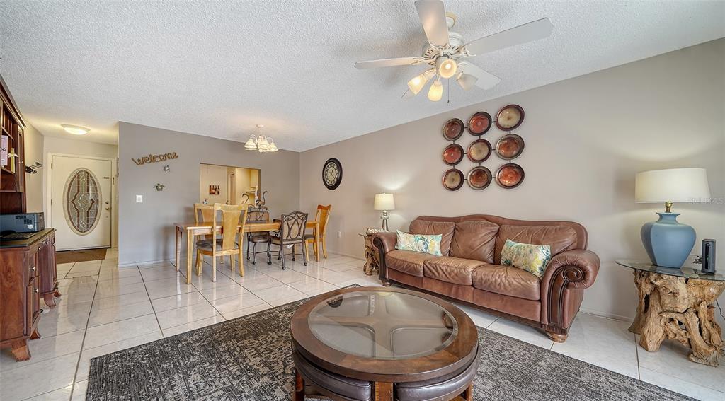 9034 Midnight Pass Road, Unit 6 Sarasota, FL 34242 - Photo 11 of 58 a living room with furniture a chandelier and a dining table