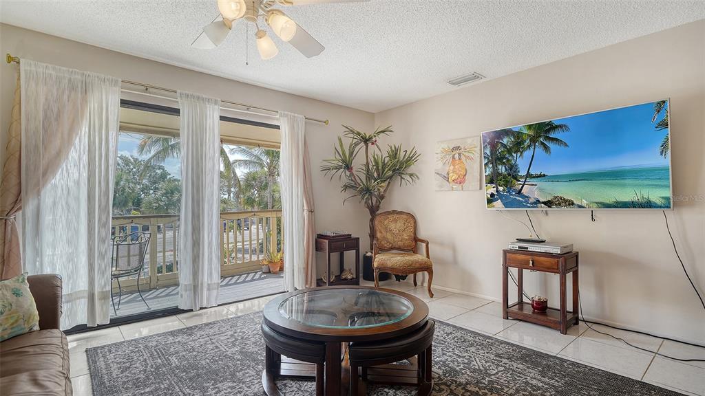 9034 Midnight Pass Road, Unit 6 Sarasota, FL 34242 - Photo 14 of 58 a living room with furniture and a flat screen tv