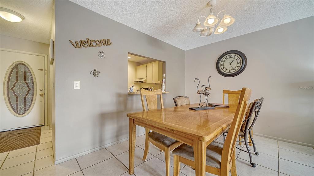 9034 Midnight Pass Road, Unit 6 Sarasota, FL 34242 - Photo 15 of 58 a view of a dining room with furniture and a clock