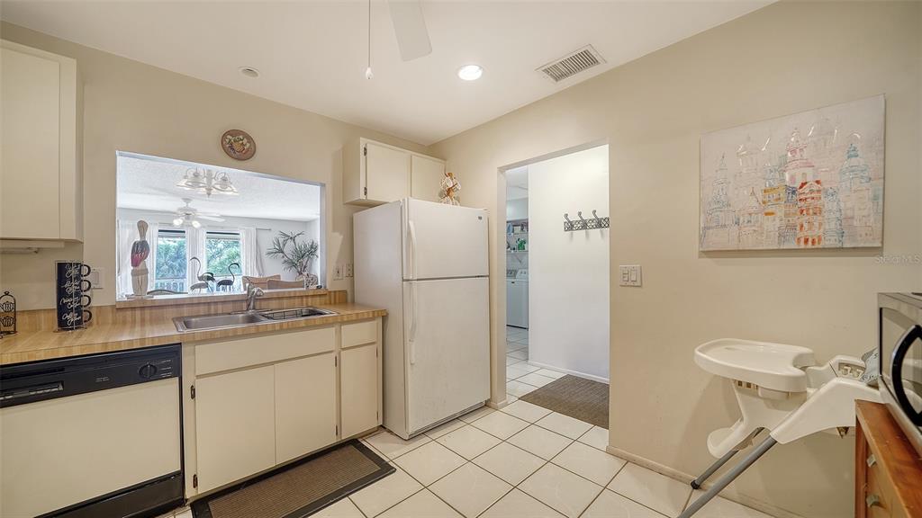9034 Midnight Pass Road, Unit 6 Sarasota, FL 34242 - Photo 18 of 58 a kitchen with a refrigerator a sink and cabinets