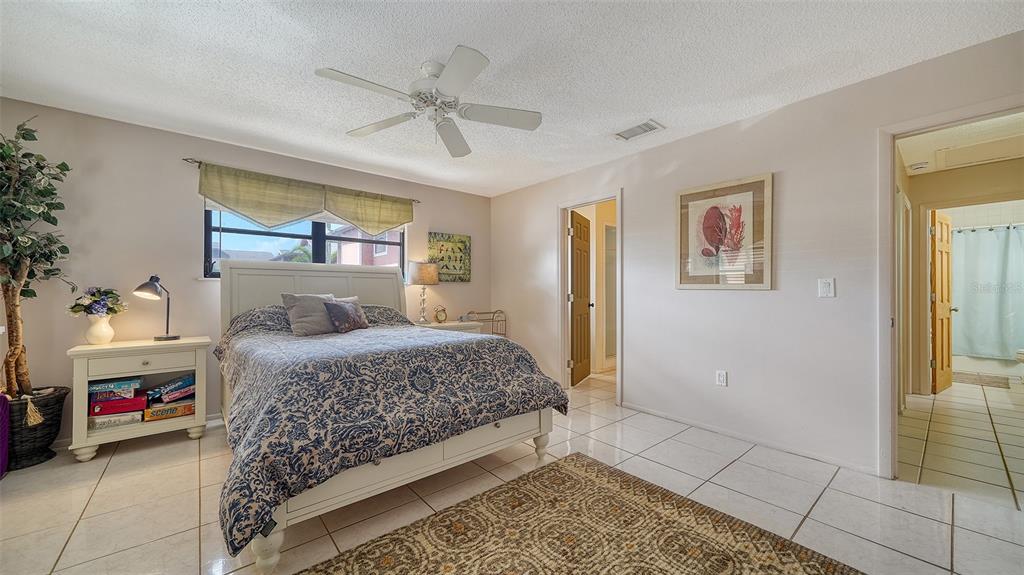 9034 Midnight Pass Road, Unit 6 Sarasota, FL 34242 - Photo 22 of 58 a bedroom with a bed and a chandelier