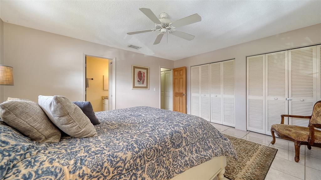 9034 Midnight Pass Road, Unit 6 Sarasota, FL 34242 - Photo 23 of 58 a bedroom with a bed and a chandelier