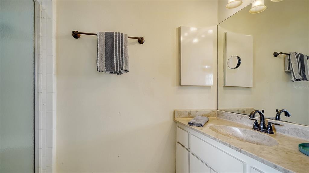 9034 Midnight Pass Road, Unit 6 Sarasota, FL 34242 - Photo 24 of 58 a bathroom with a granite countertop sink and mirror