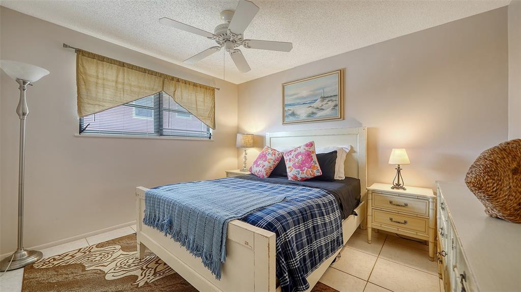 9034 Midnight Pass Road, Unit 6 Sarasota, FL 34242 - Photo 25 of 58 a bedroom with a bed and a chandelier