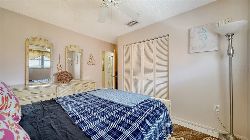 9034 Midnight Pass Road, Unit 6 Sarasota, FL 34242 - Photo 27 of 58 a bedroom with a bed and a mirror