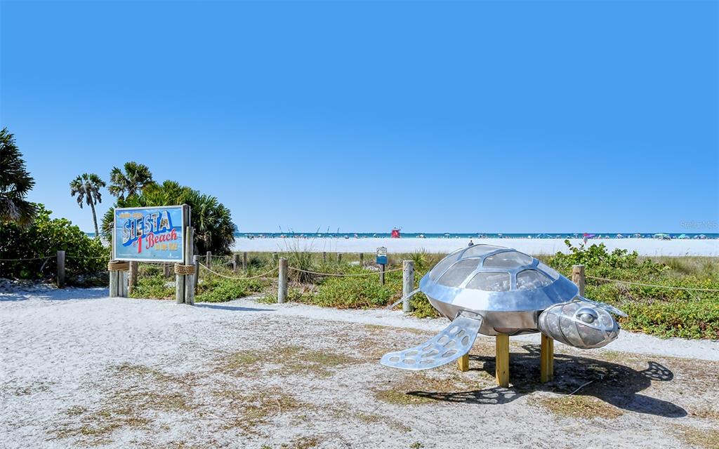 9034 Midnight Pass Road, Unit 6 Sarasota, FL 34242 - Photo 43 of 58 a table and chairs under an umbrella