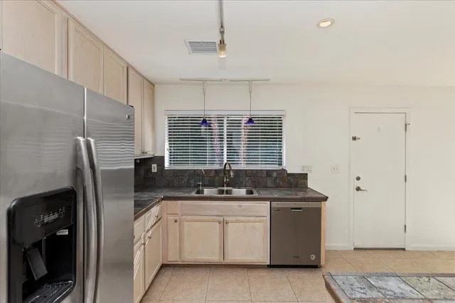 a kitchen with stainless steel appliances granite countertop a sink and a refrigerator