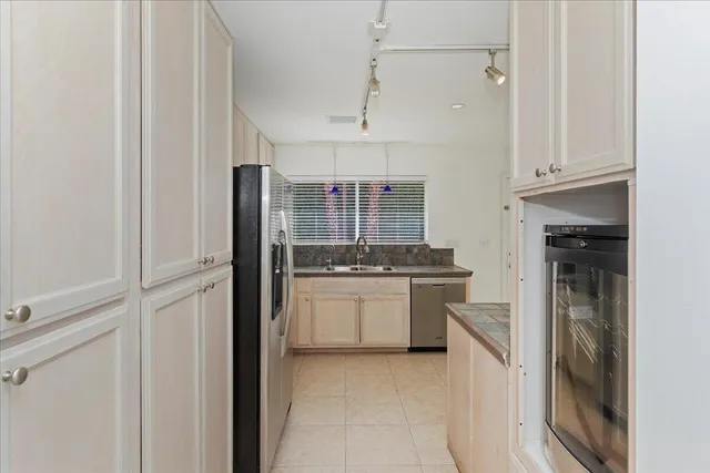 a kitchen with stainless steel appliances granite countertop a refrigerator and a stove top oven
