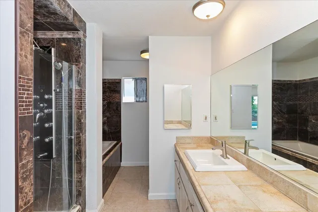 a bathroom with a tub sink and mirror