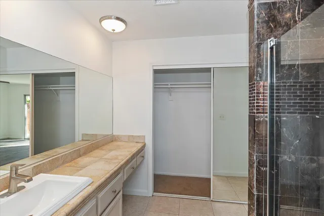a bathroom with a granite countertop sink and a mirror