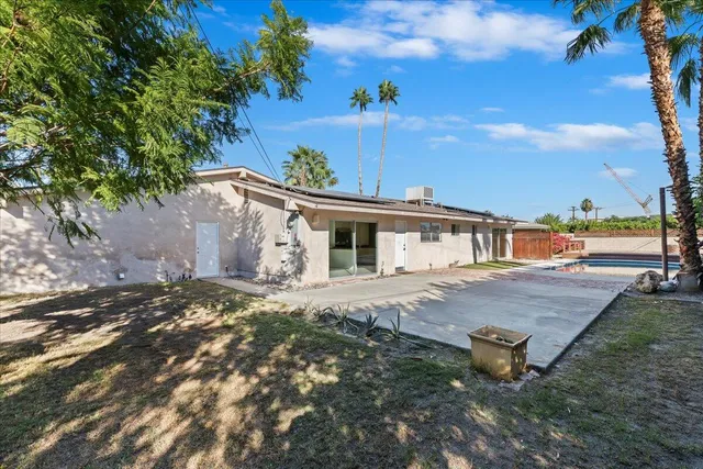a view of a house with backyard and a tree