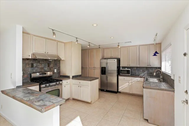 a kitchen with a sink a refrigerator and cabinets