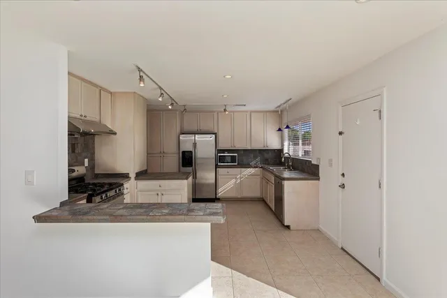 a large white kitchen with cabinets and stainless steel appliances