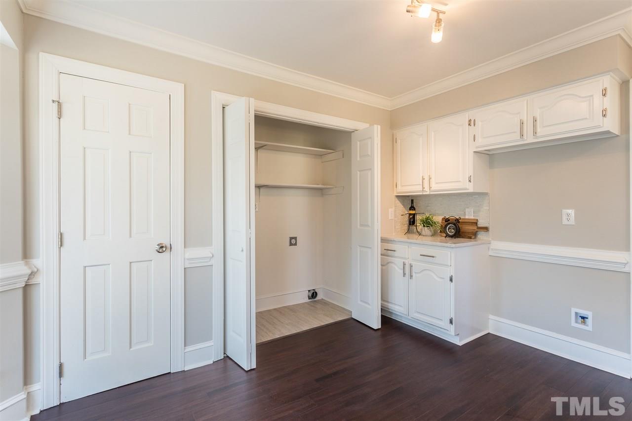 3117 East Folkestone Place Raleigh, NC 27604 - Photo 8 of 24 a kitchen with granite countertop white cabinets and wooden floor