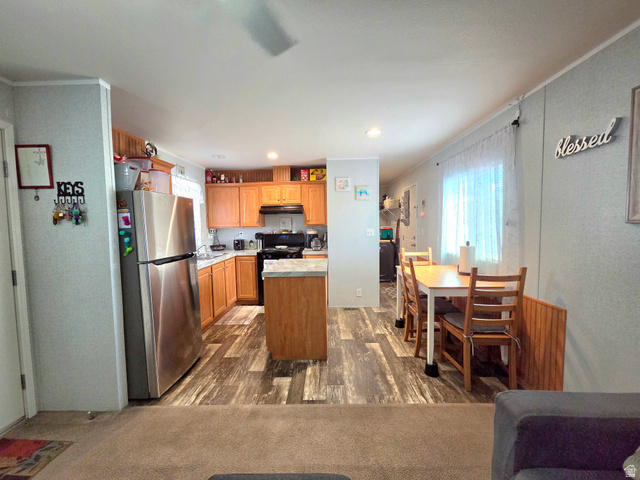 597 North State Street, Unit 67 Orem, UT 84057 - Photo 8 of 23 Kitchen featuring freestanding refrigerator, light countertops, a kitchen island, gas stove, and dark wood finished floors