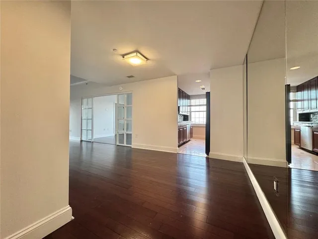 a view of empty room with wooden floor