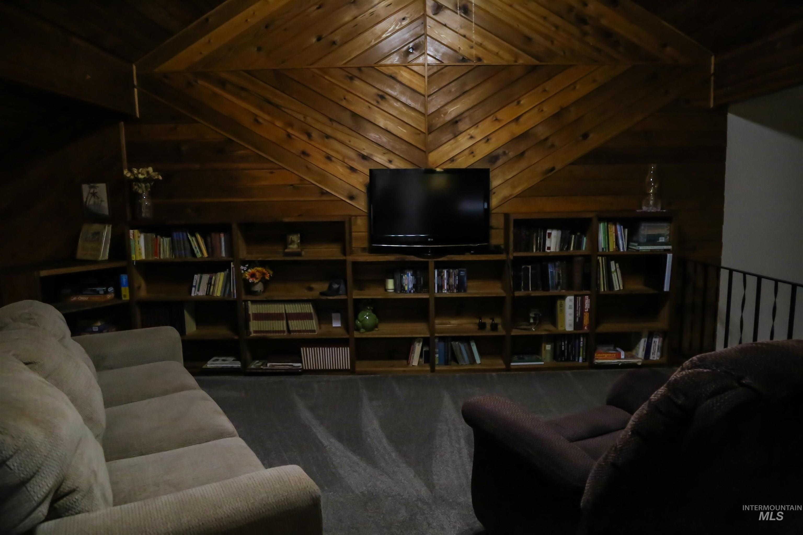 2060 Missman Road Council, ID 83612 - Photo 15 of 50 Living area featuring dark carpet and wooden walls