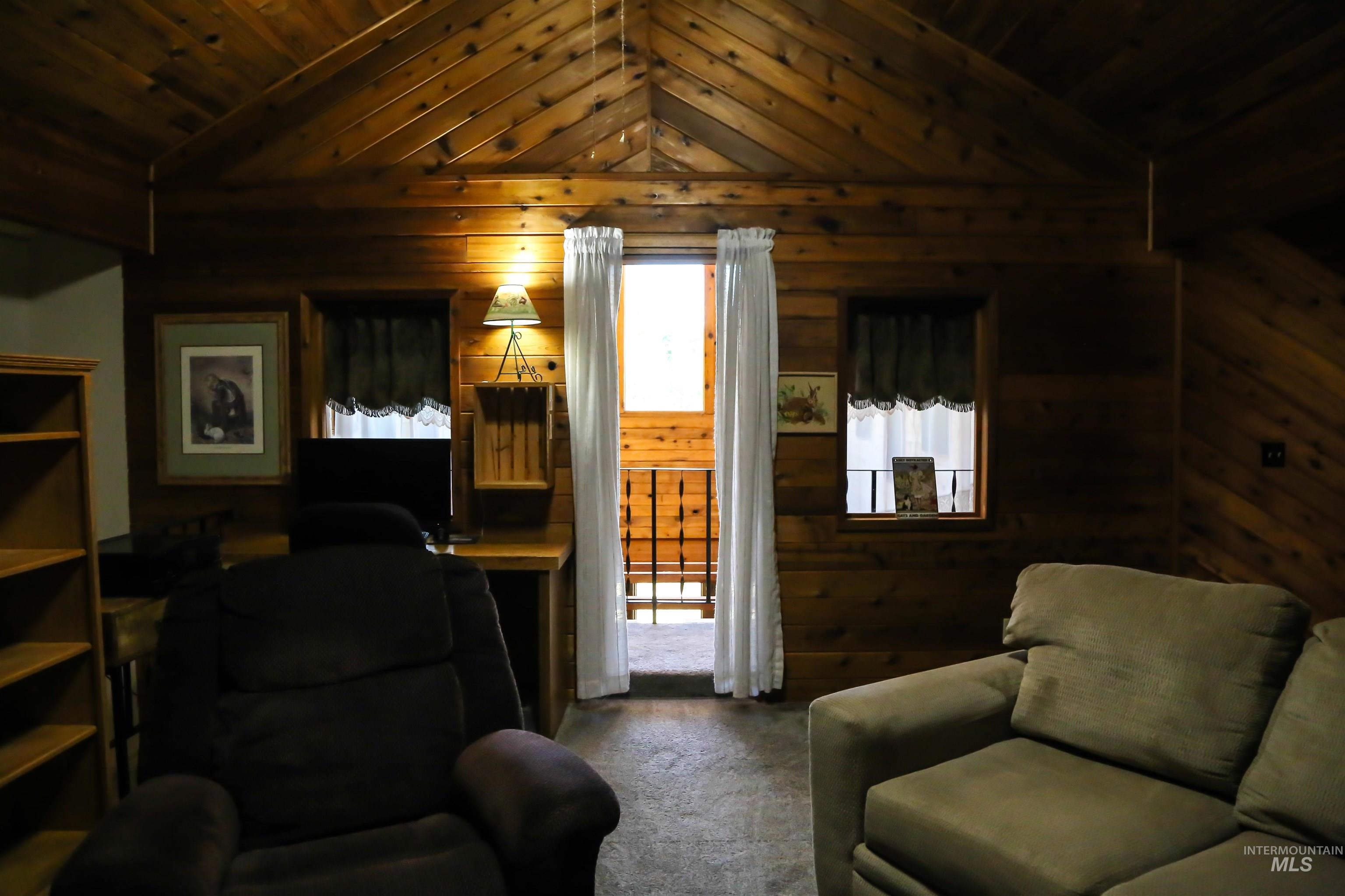 2060 Missman Road Council, ID 83612 - Photo 17 of 50 Family room featuring carpet, wooden ceiling, and wooden walls