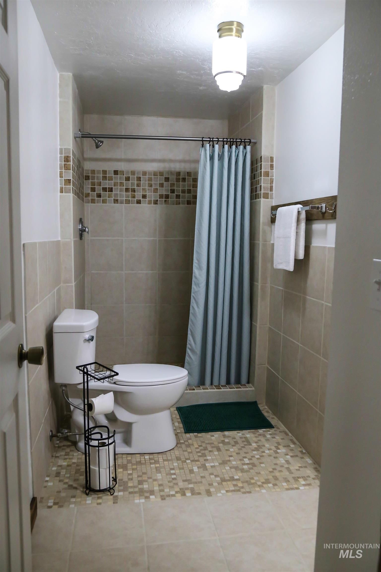 2060 Missman Road Council, ID 83612 - Photo 18 of 50 Full bathroom with a shower stall, tile patterned floors, and tile walls