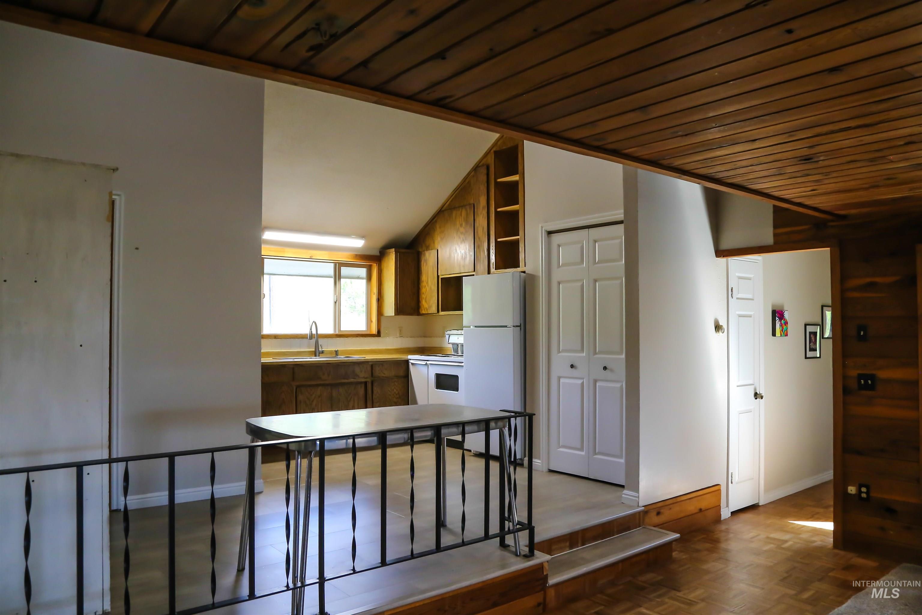 2060 Missman Road Council, ID 83612 - Photo 2 of 50 Kitchen featuring open shelves, white appliances, a vaulted wooden ceiling, wood finish cabinetry, and light countertops
