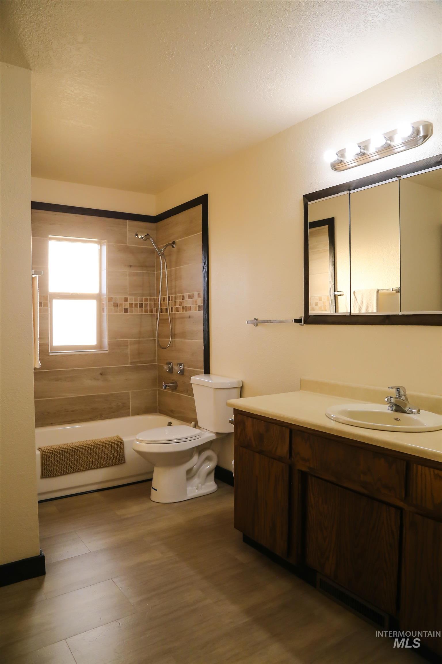 2060 Missman Road Council, ID 83612 - Photo 24 of 50 Bathroom featuring vanity, washtub / shower combination, a textured ceiling, and dark wood-style flooring