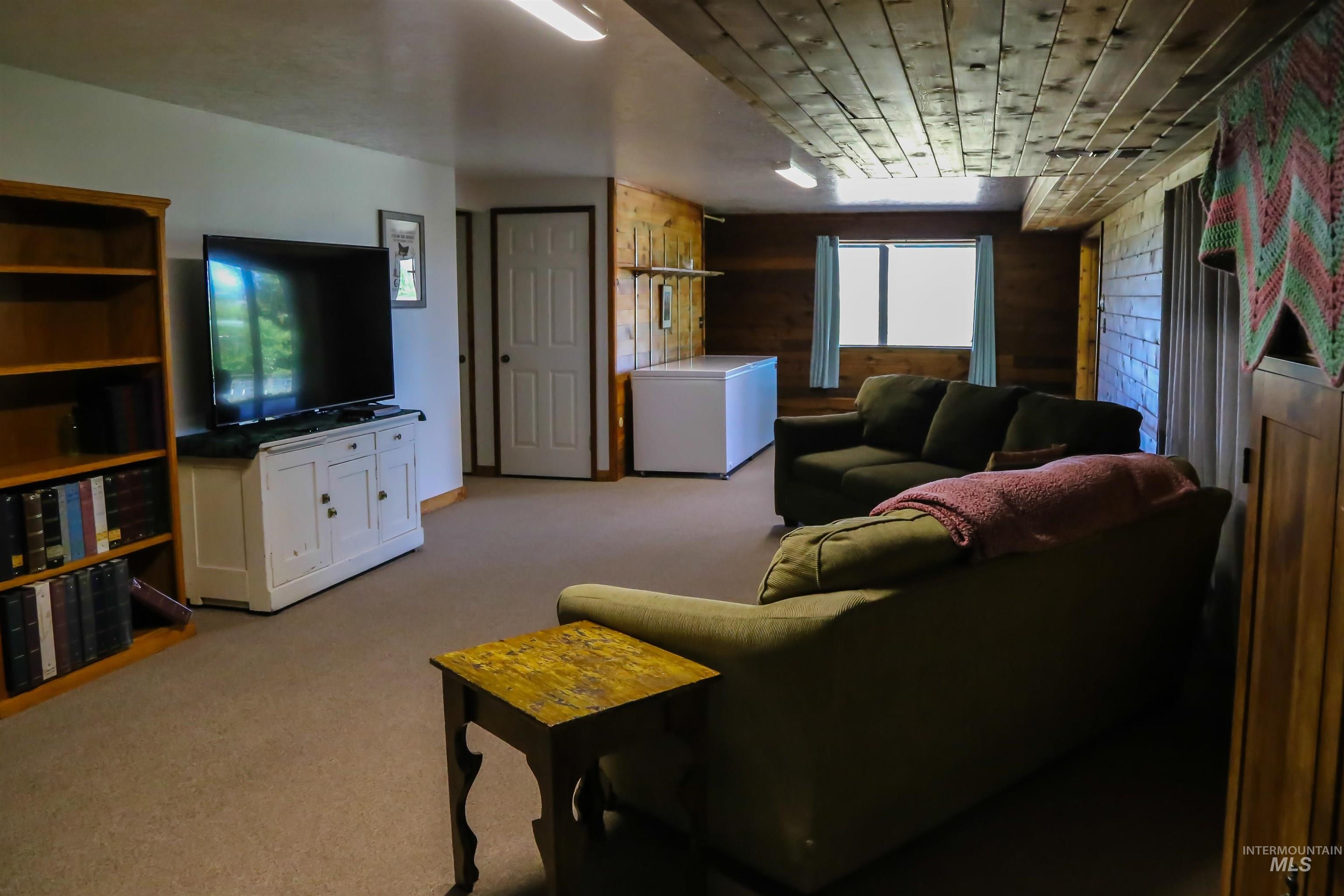 2060 Missman Road Council, ID 83612 - Photo 26 of 50 Living room with wooden walls and light carpet