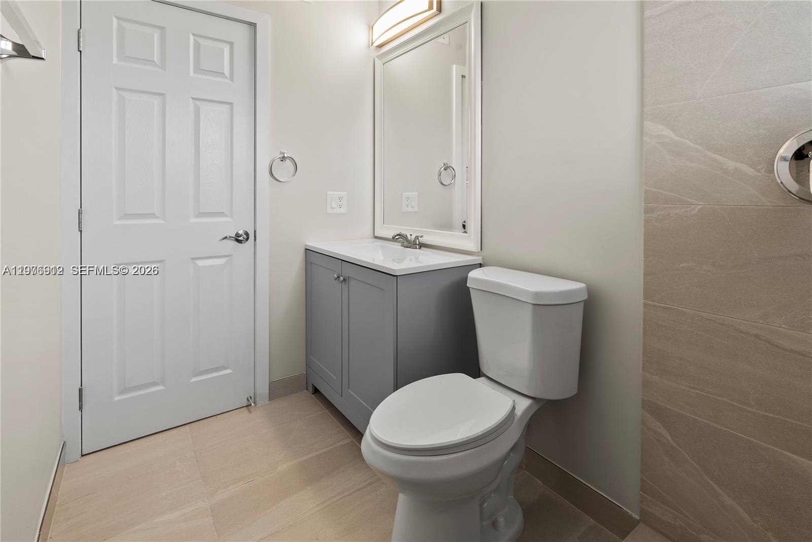 1101 Northeast 80th Street, Unit 201 Miami, FL 33138 - Photo 11 of 17 a white toilet sitting next to a bathroom sink