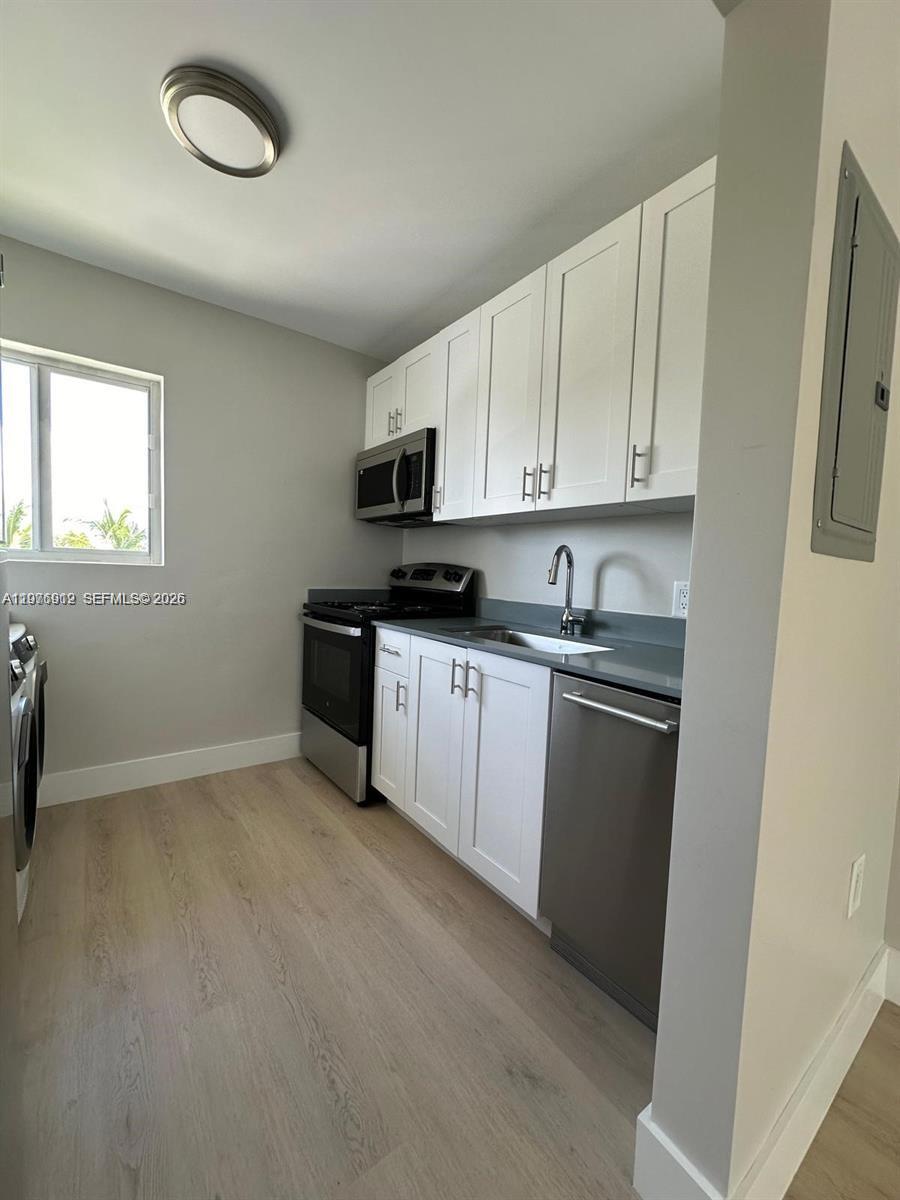 1101 Northeast 80th Street, Unit 201 Miami, FL 33138 - Photo 15 of 17 a kitchen with granite countertop a sink a stove a microwave and cabinets