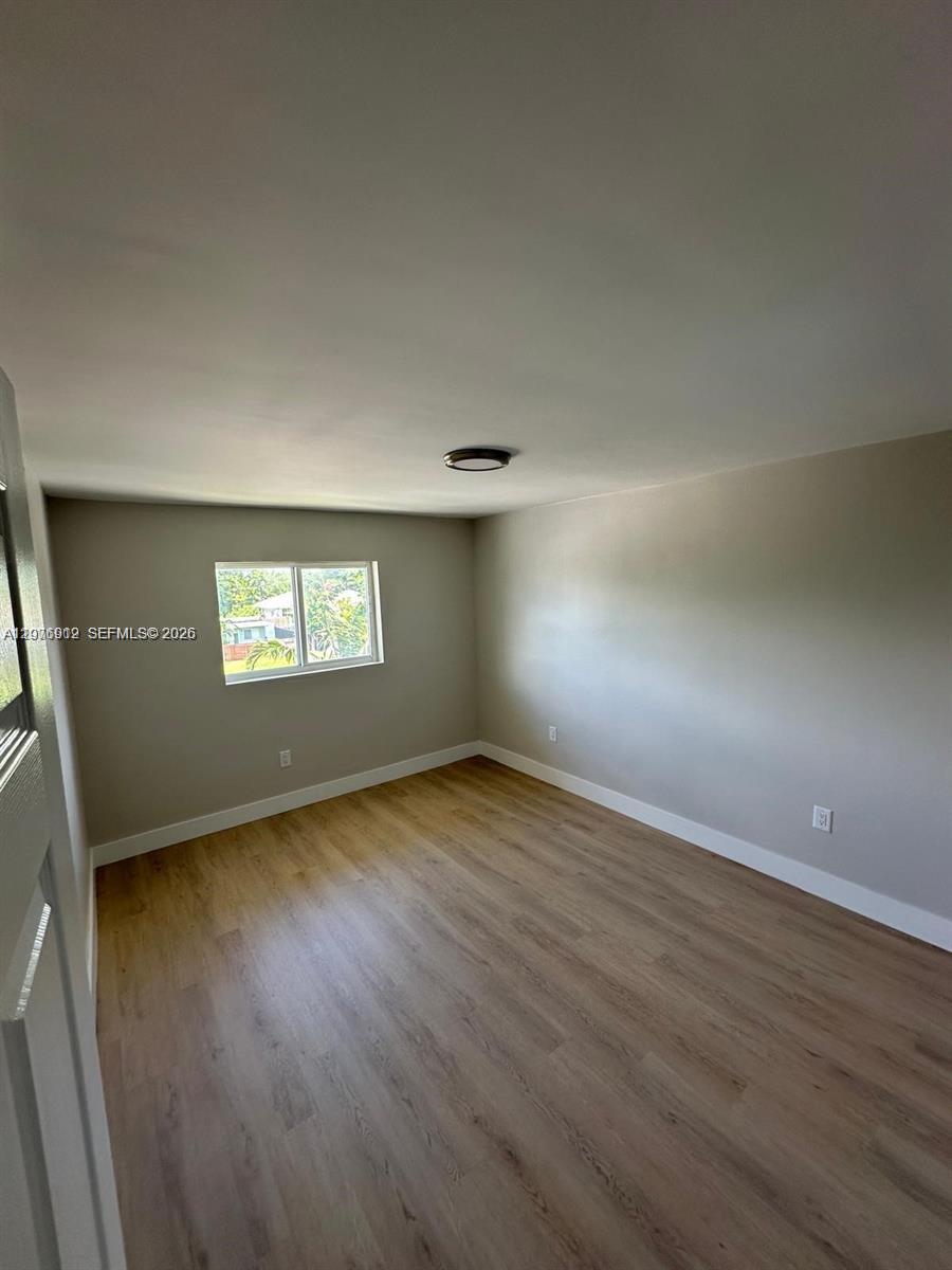 1101 Northeast 80th Street, Unit 201 Miami, FL 33138 - Photo 16 of 17 an empty room with wooden floor and windows
