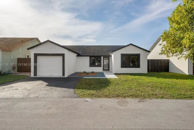 a front view of a house with a yard and garage