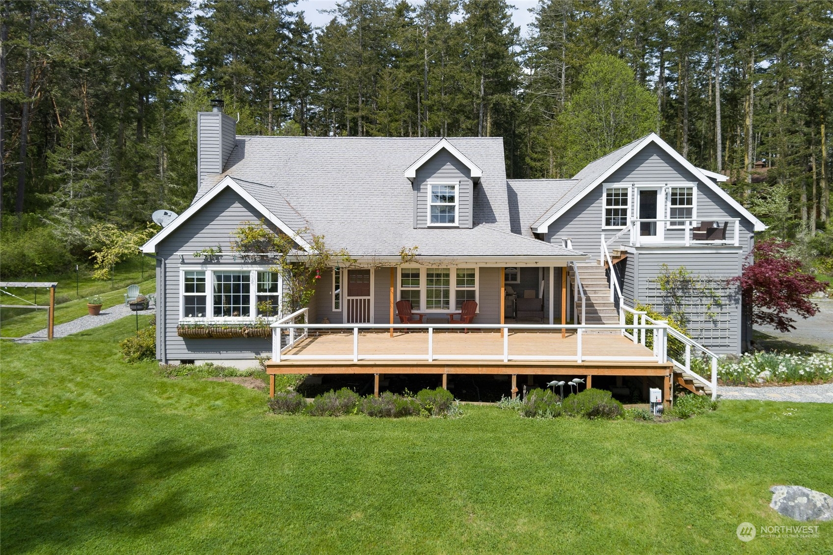 2858 Pear Point Road Friday Harbor, WA 98250 - Photo 1 of 40 a front view of a house with a yard table and chairs