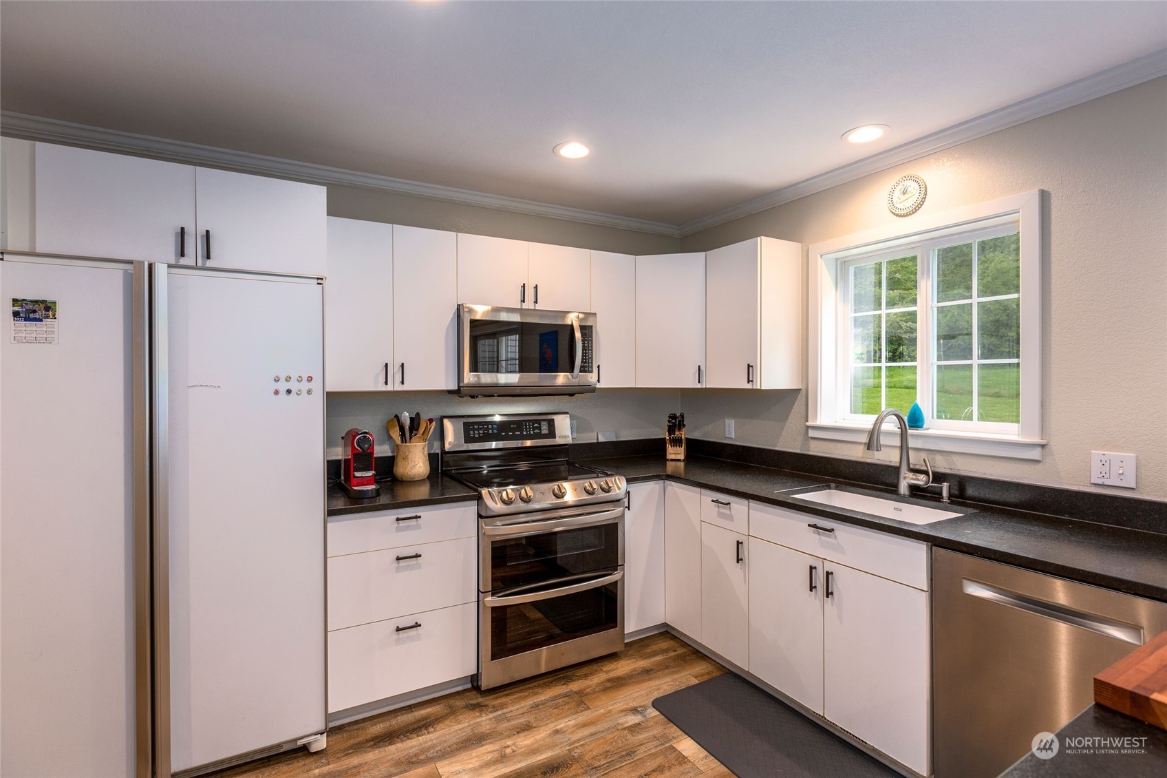 2858 Pear Point Road Friday Harbor, WA 98250 - Photo 20 of 40 a kitchen with granite countertop white cabinets and stainless steel appliances