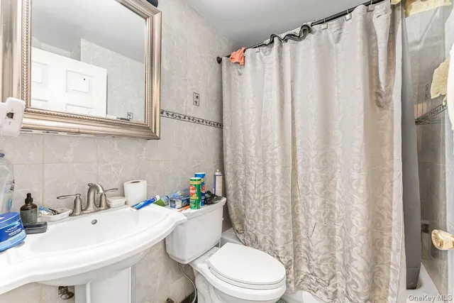 a bathroom with a sink a toilet and shower curtain