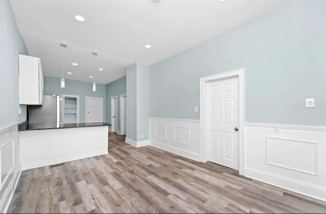 a view of kitchen with white cabinets and wooden floor