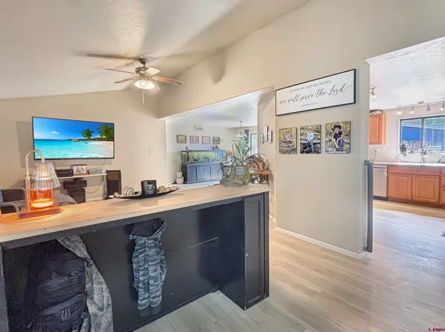 a kitchen with stainless steel appliances granite countertop a refrigerator a sink dishwasher and a stove with wooden floor