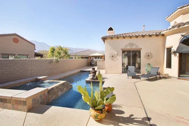 a view of a patio with table and chairs with barbeque grill and wooden fence