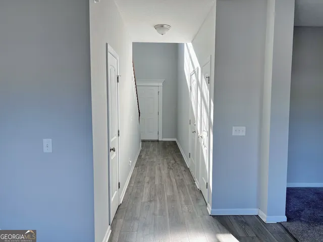 a view of a hallway with wooden floor