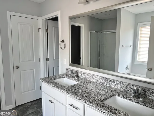 a bathroom with a granite countertop sink and a mirror