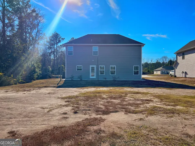 a view of a house with backyard and trees