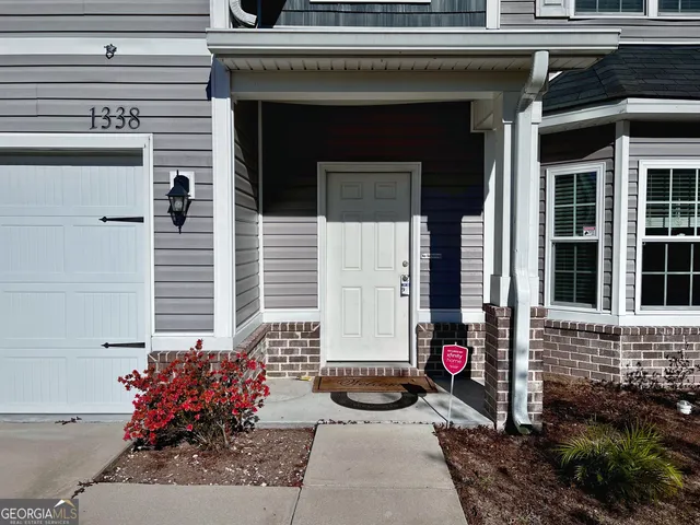 a view of a house with red door and a bench