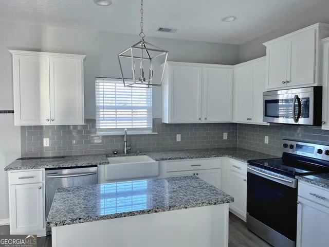 a kitchen with stainless steel appliances granite countertop a sink stove and microwave