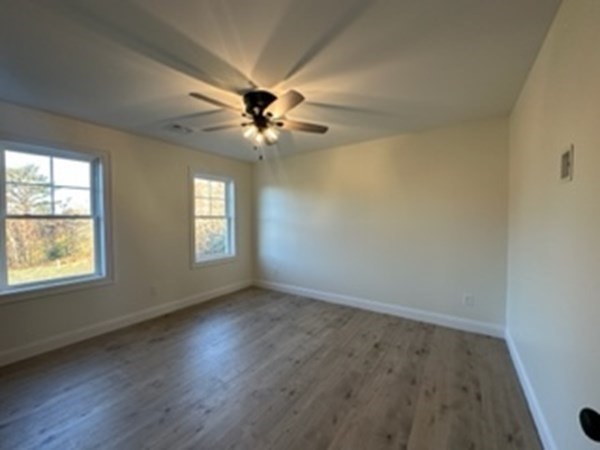 1479 Main Street Acushnet, MA 02743 - Photo 11 of 23 an empty room with wooden floor ceiling fan and windows