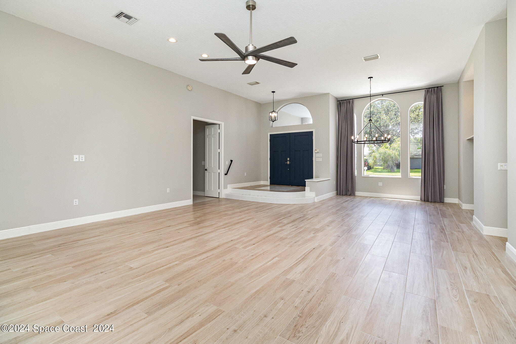 697 Spring Lake Drive Melbourne, FL 32940 - Photo 12 of 51 a view of an empty room with a window and wooden floor