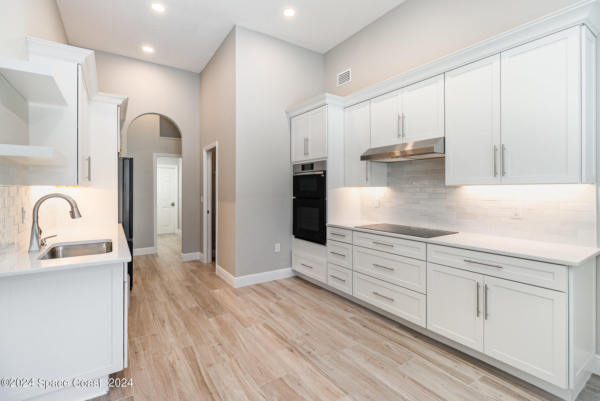 697 Spring Lake Drive Melbourne, FL 32940 - Photo 13 of 51 a kitchen with granite countertop white cabinets and stainless steel appliances