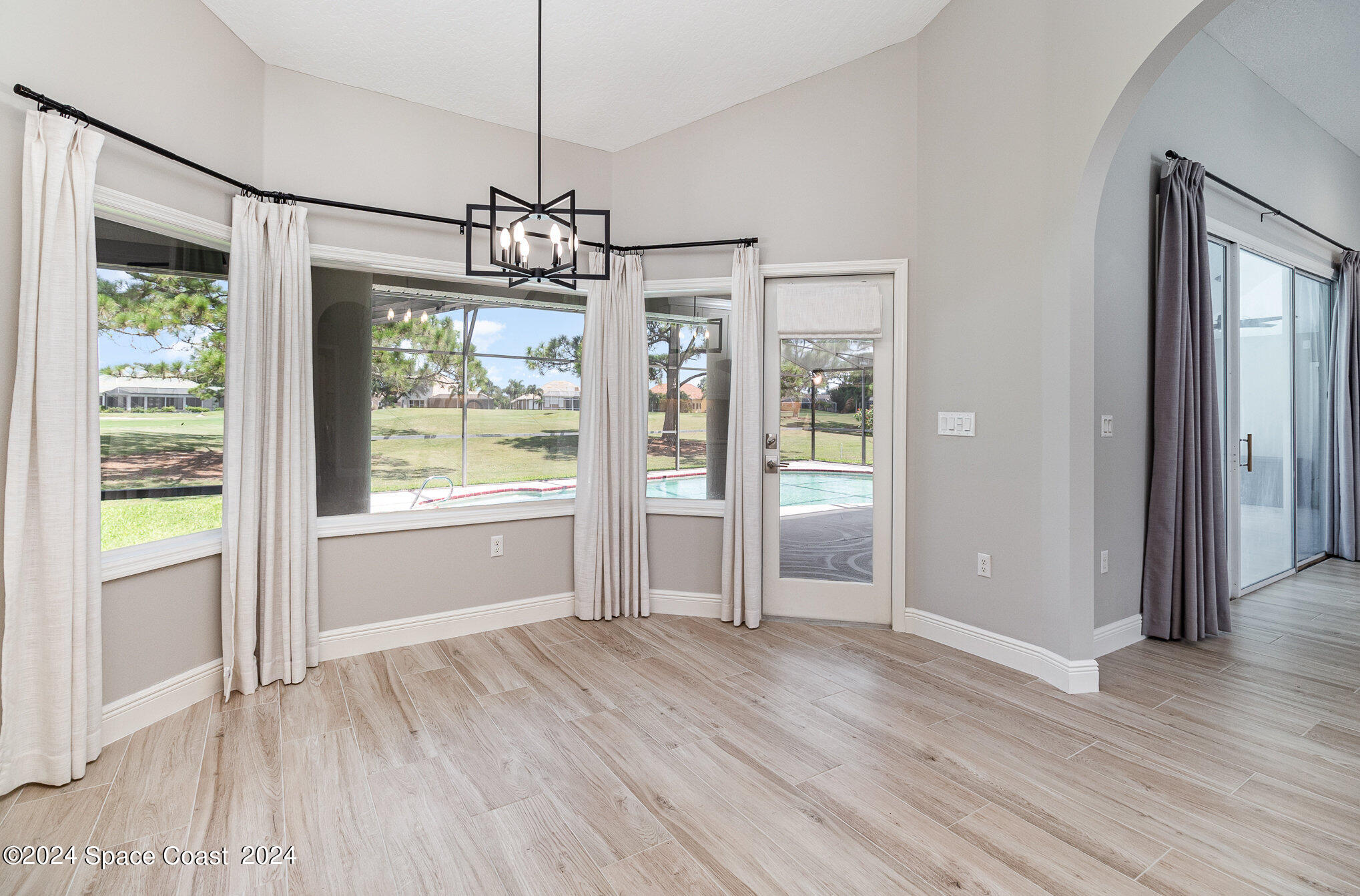 697 Spring Lake Drive Melbourne, FL 32940 - Photo 15 of 51 a view of an empty room with wooden floor and a window