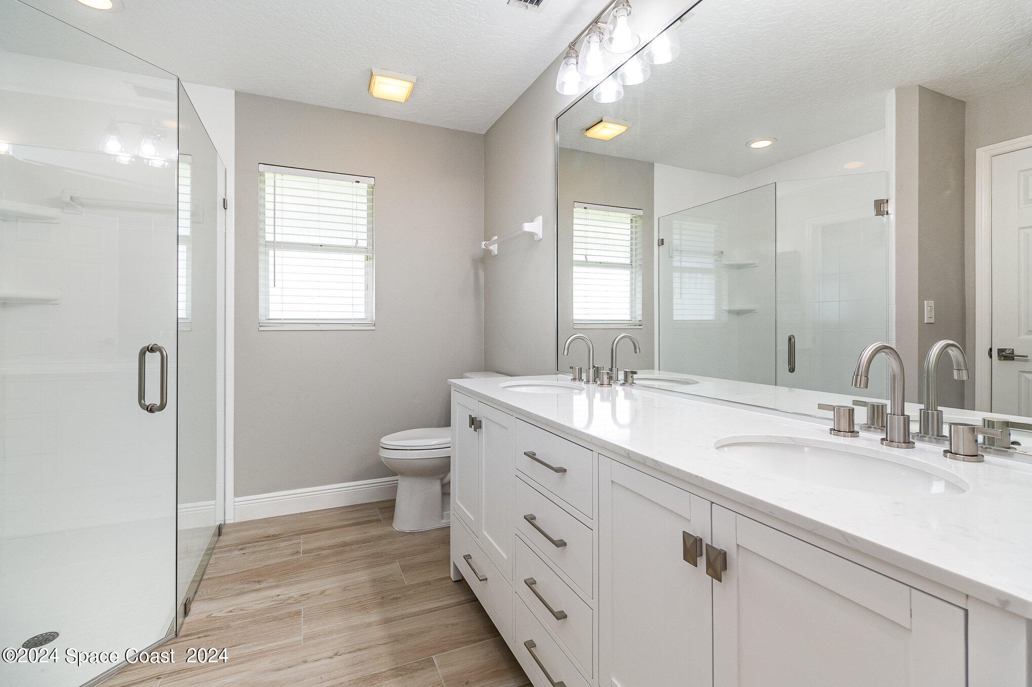 697 Spring Lake Drive Melbourne, FL 32940 - Photo 25 of 51 a spacious bathroom with a double vanity sink a mirror and a toilet