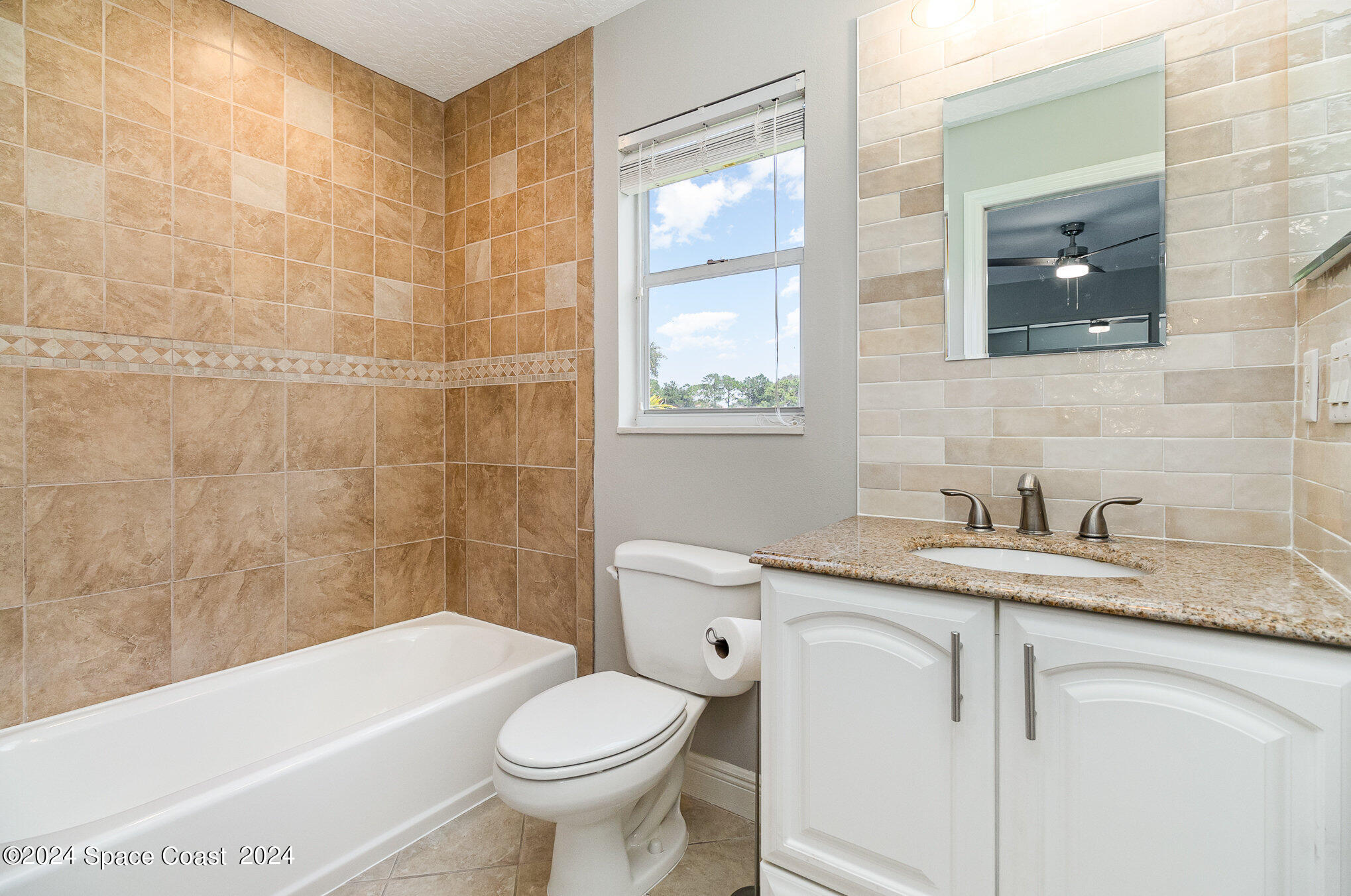697 Spring Lake Drive Melbourne, FL 32940 - Photo 29 of 51 a bathroom with a granite countertop sink toilet and shower